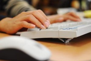 mãos digitando em um computador